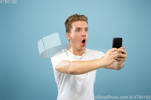 Image of Caucasian young man\'s half-length portrait on blue background