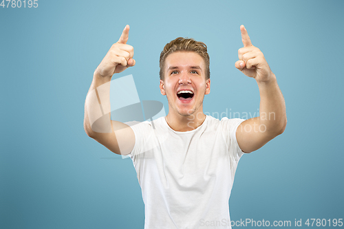 Image of Caucasian young man\'s half-length portrait on blue background