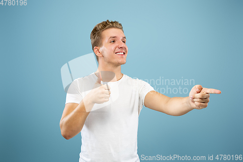 Image of Caucasian young man\'s half-length portrait on blue background