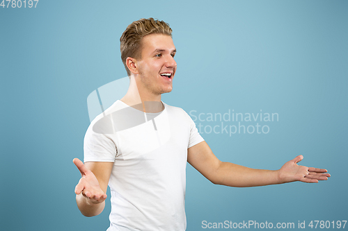 Image of Caucasian young man\'s half-length portrait on blue background