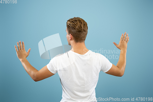 Image of Caucasian young man\'s half-length portrait on blue background