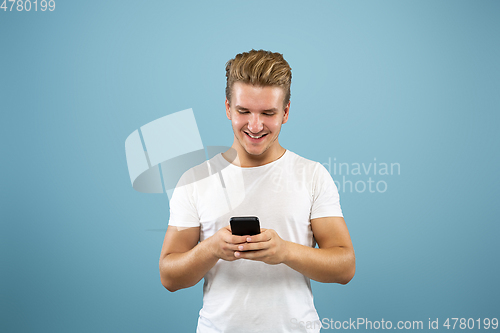 Image of Caucasian young man\'s half-length portrait on blue background