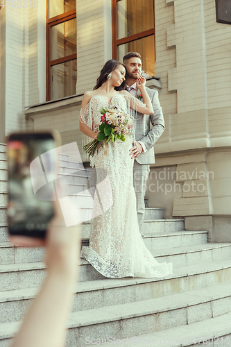 Image of Caucasian romantic young bride celebrating his marriage in city