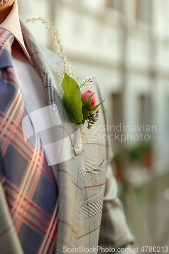 Image of Caucasian romantic young groom celebrating his marriage in city