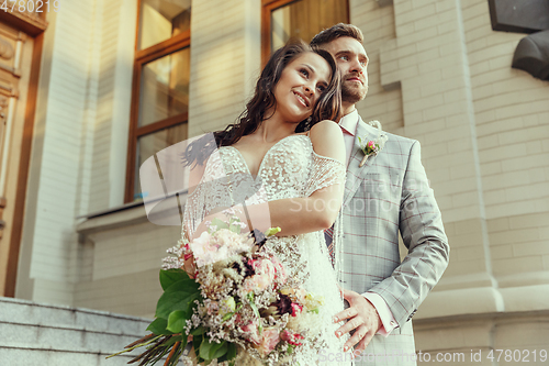 Image of Caucasian romantic young couple celebrating their marriage in city