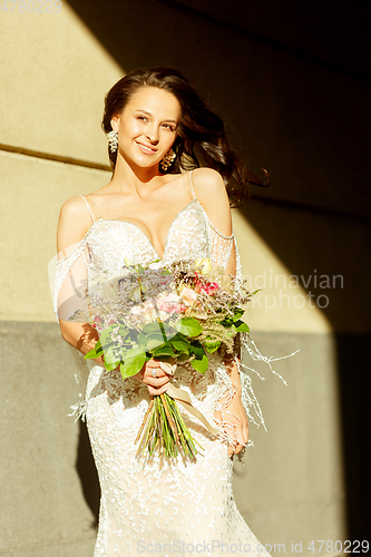 Image of Caucasian romantic young groom celebrating his marriage in city