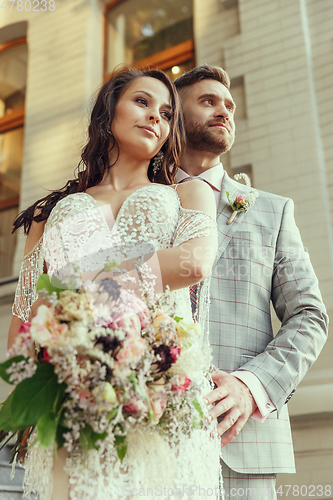 Image of Caucasian romantic young couple celebrating their marriage in city