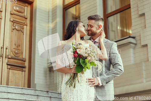 Image of Caucasian romantic young couple celebrating their marriage in city