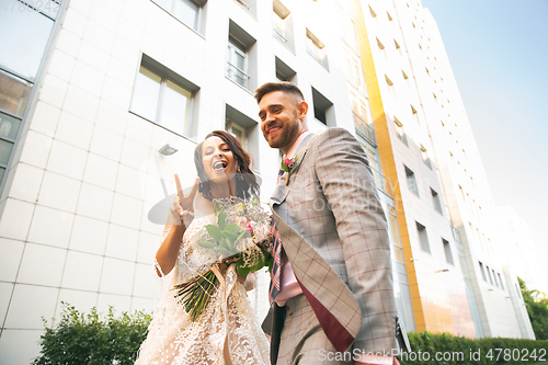 Image of Caucasian romantic young couple celebrating their marriage in city