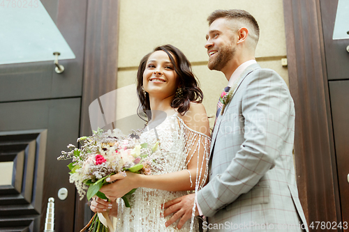 Image of Caucasian romantic young couple celebrating their marriage in city