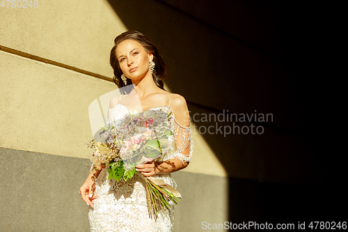 Image of Caucasian romantic young groom celebrating his marriage in city