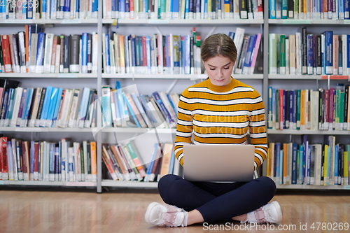 Image of the student uses a notebook and a school library