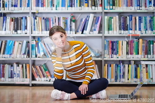 Image of the student uses a notebook and a school library