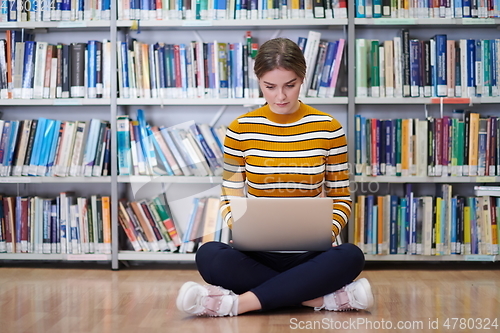 Image of the student uses a notebook and a school library