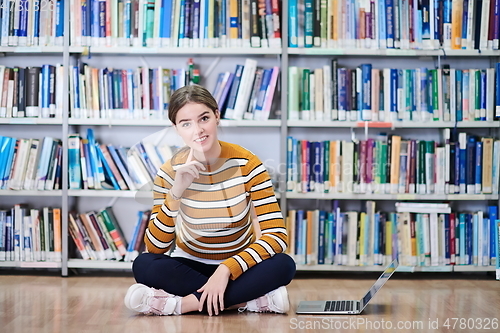 Image of the student uses a notebook and a school library