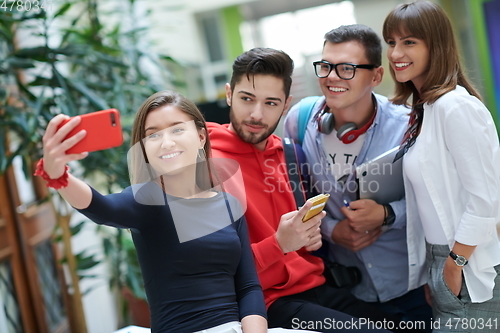 Image of Group of multiethnic teenagers taking a selfie in school