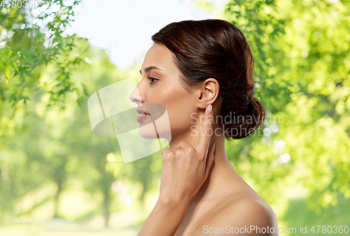 Image of beautiful young woman pointing finger to her ear