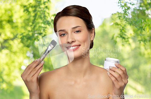 Image of beautiful young woman with facial mask and brush