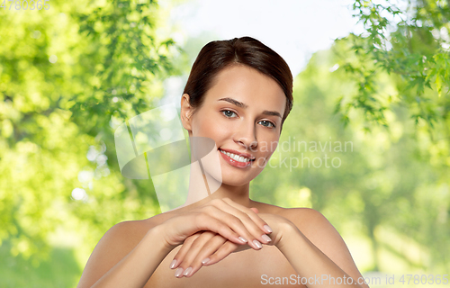 Image of beautiful young woman moisturizing her hands skin