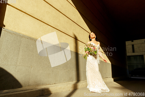 Image of Caucasian romantic young groom celebrating his marriage in city