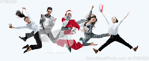 Image of Happy Christmas Santa Claus jumping on studio background