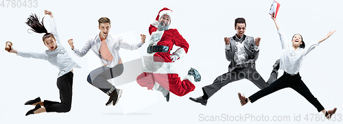 Image of Happy Christmas Santa Claus jumping on studio background