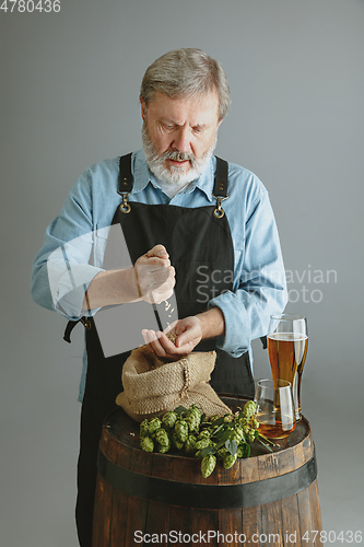 Image of Confident senior man brewer with self crafted beer