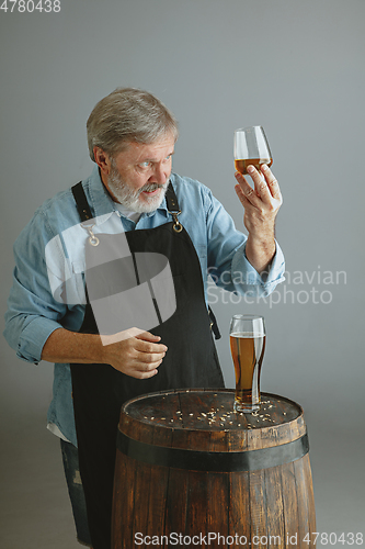 Image of Confident senior man brewer with self crafted beer