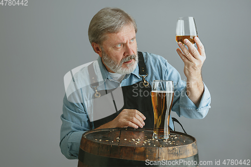 Image of Confident senior man brewer with self crafted beer