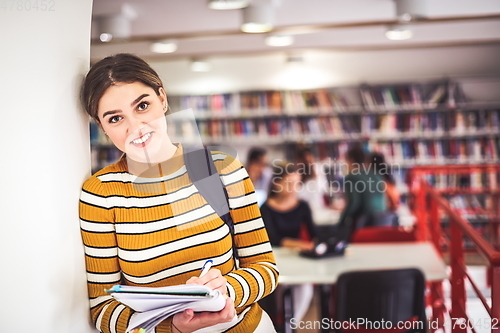 Image of the student uses a notebook and a school library