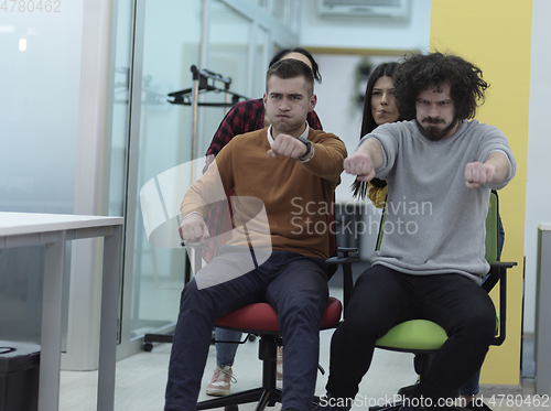 Image of Multiethnic startup group at office chair race