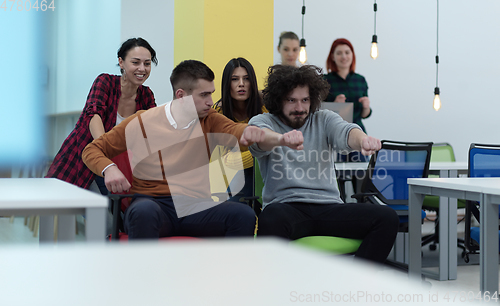 Image of Multiethnic startup group at office chair race