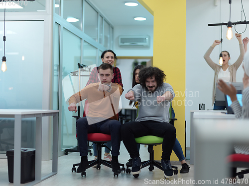 Image of Multiethnic startup group at office chair race