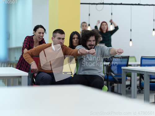 Image of Multiethnic startup group at office chair race