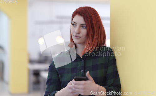 Image of redhead business woman at office using smart phone