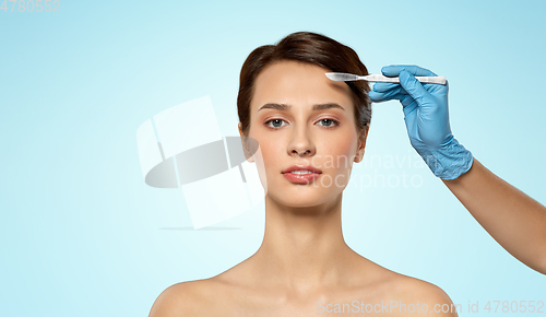 Image of beautiful young woman and hand with scalpel