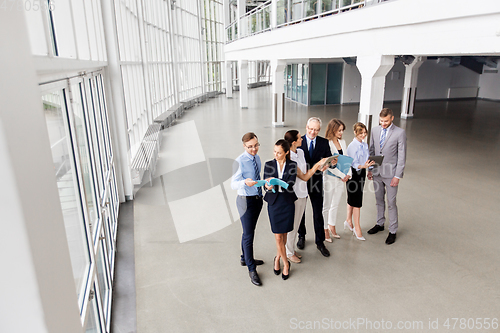 Image of business team with tablet pc and folders at office