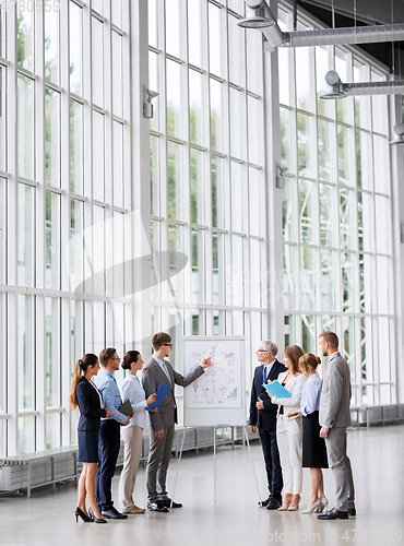 Image of business team with scheme on flip chart at office