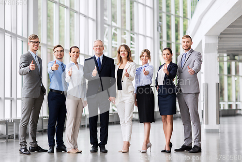 Image of business people showing thumbs up at office