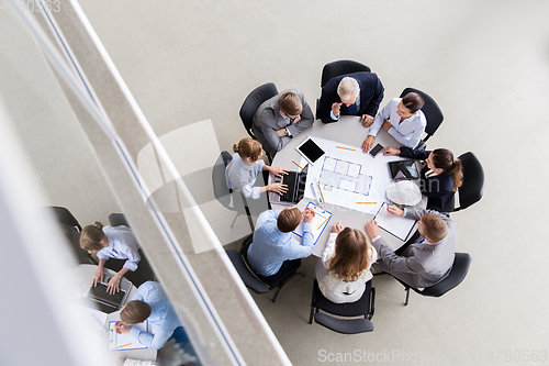 Image of architects with laptop and blueprint at office