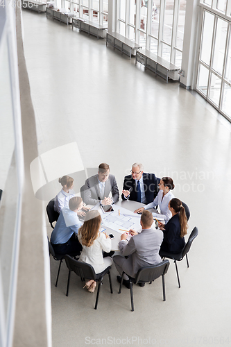 Image of architects with laptop and blueprint at office