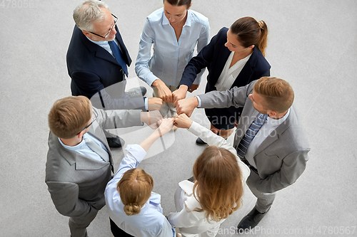 Image of happy business people making fist bump