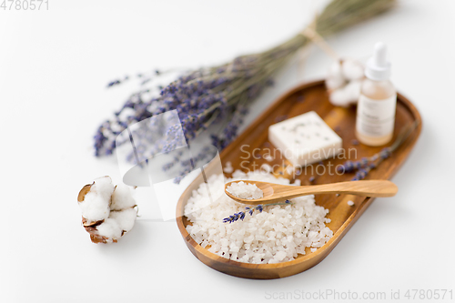 Image of sea salt, lavender soap and serum on wooden tray