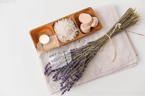 Image of sea salt, soap, candle and lavender on bath towel