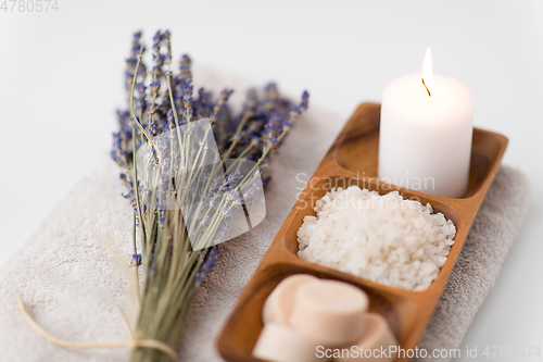 Image of sea salt, soap, candle and lavender on bath towel