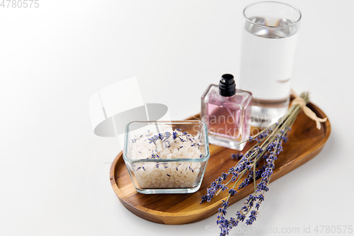 Image of sea salt, perfume and lavender on wooden tray