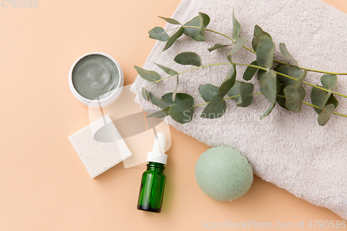 Image of serum, clay mask, oil and eucalyptus on bath towel