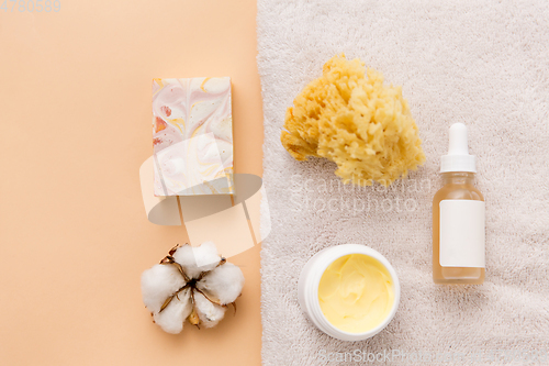 Image of body butter, essential oil, sponge on bath towel