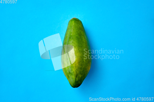 Image of close up of ripe papaya on blue background