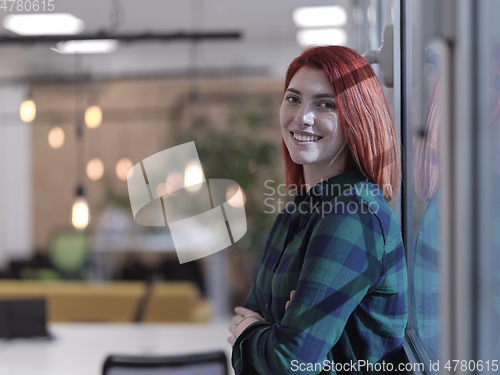 Image of redhead business woman portrait in creative modern coworking startup open space office